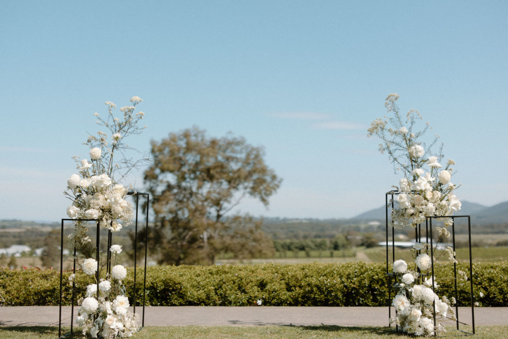 Wedding arbor with white flowers and black metal cages