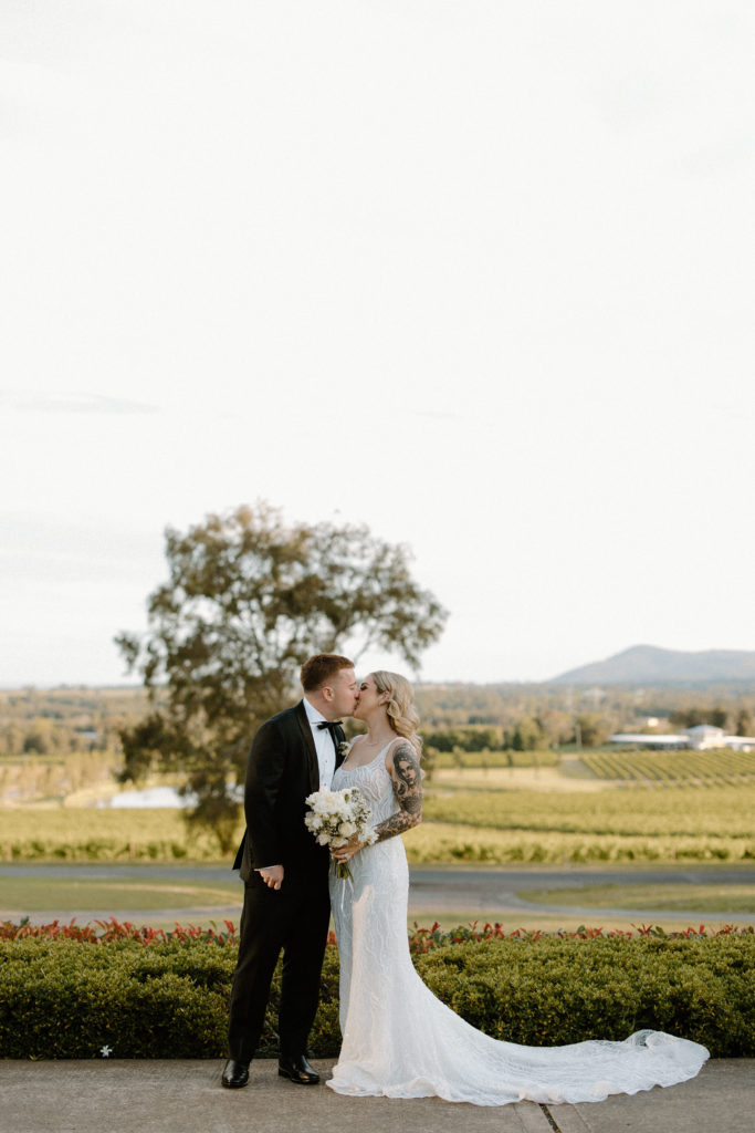 Bride and groom, standing in front of a vineyard kidding